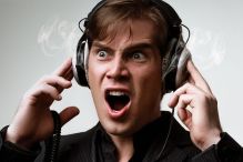 Mann hört schlechte Musik auf Kopfhörern und bekommt einen Ohrwurm